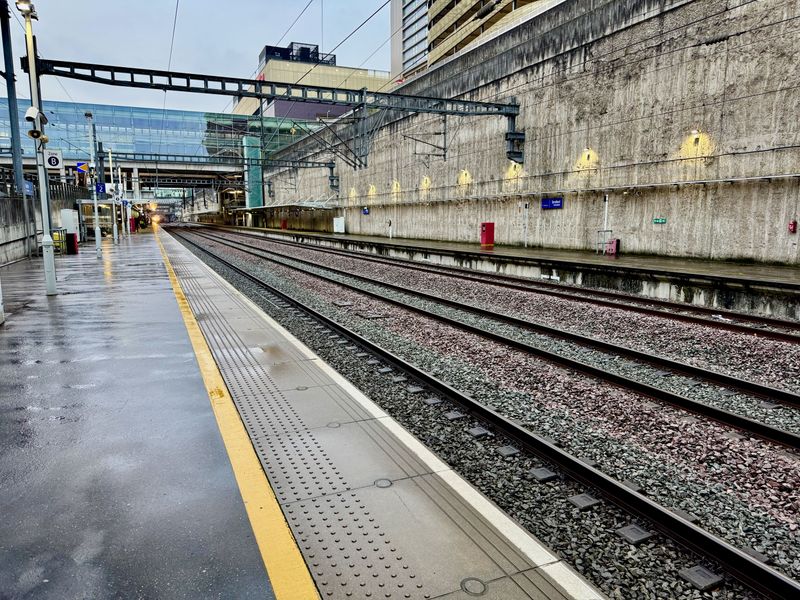 Looking down a wet train platform at Stratford International