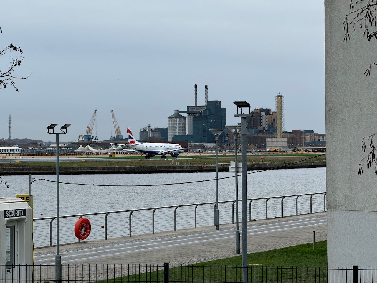 Aeroplane waiting on the runway to take off with a body of water in the foreground