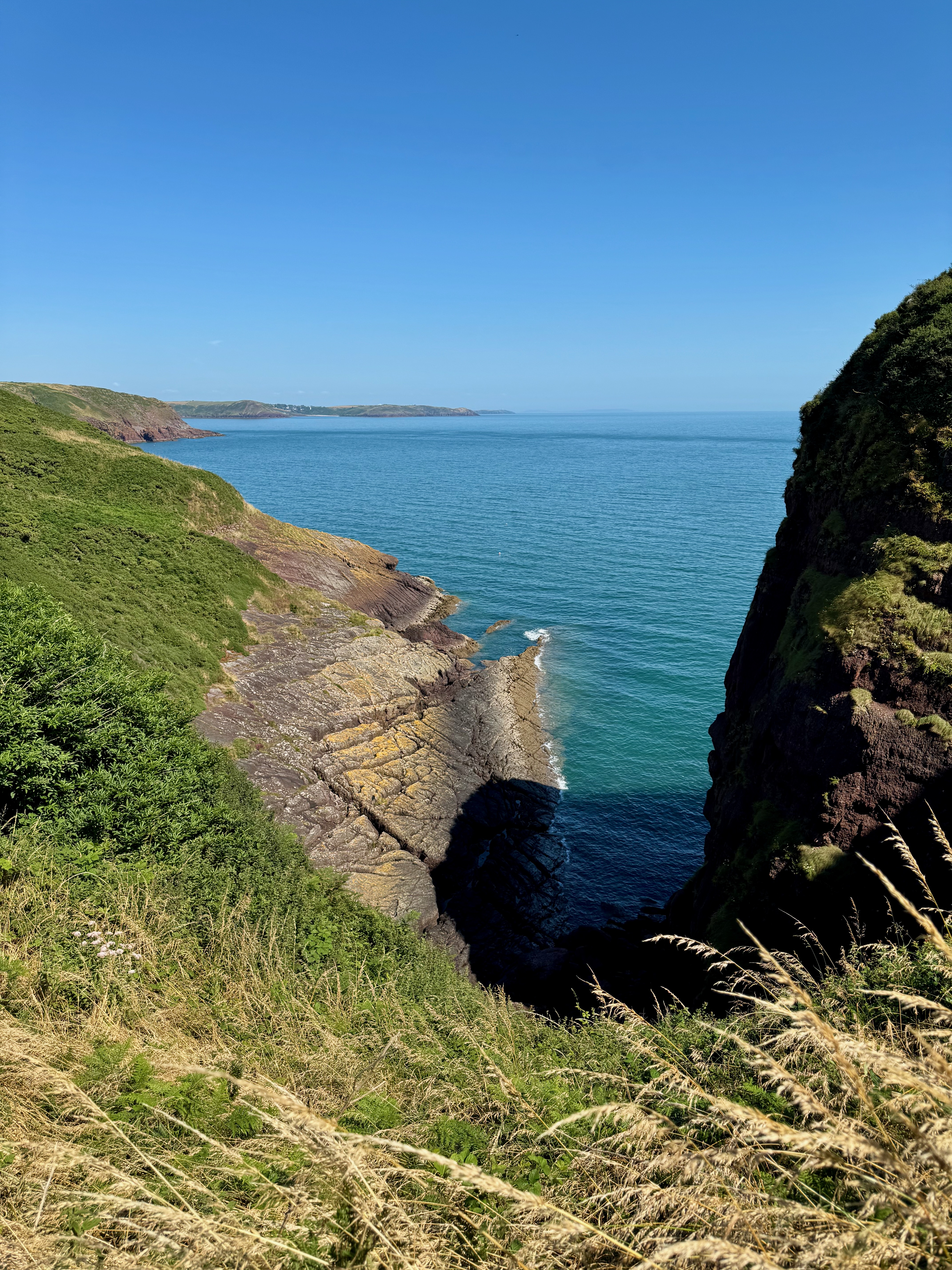 Standing at the end of a crack leading from the sea down below up to the trail. Steep rock faces on both sides.