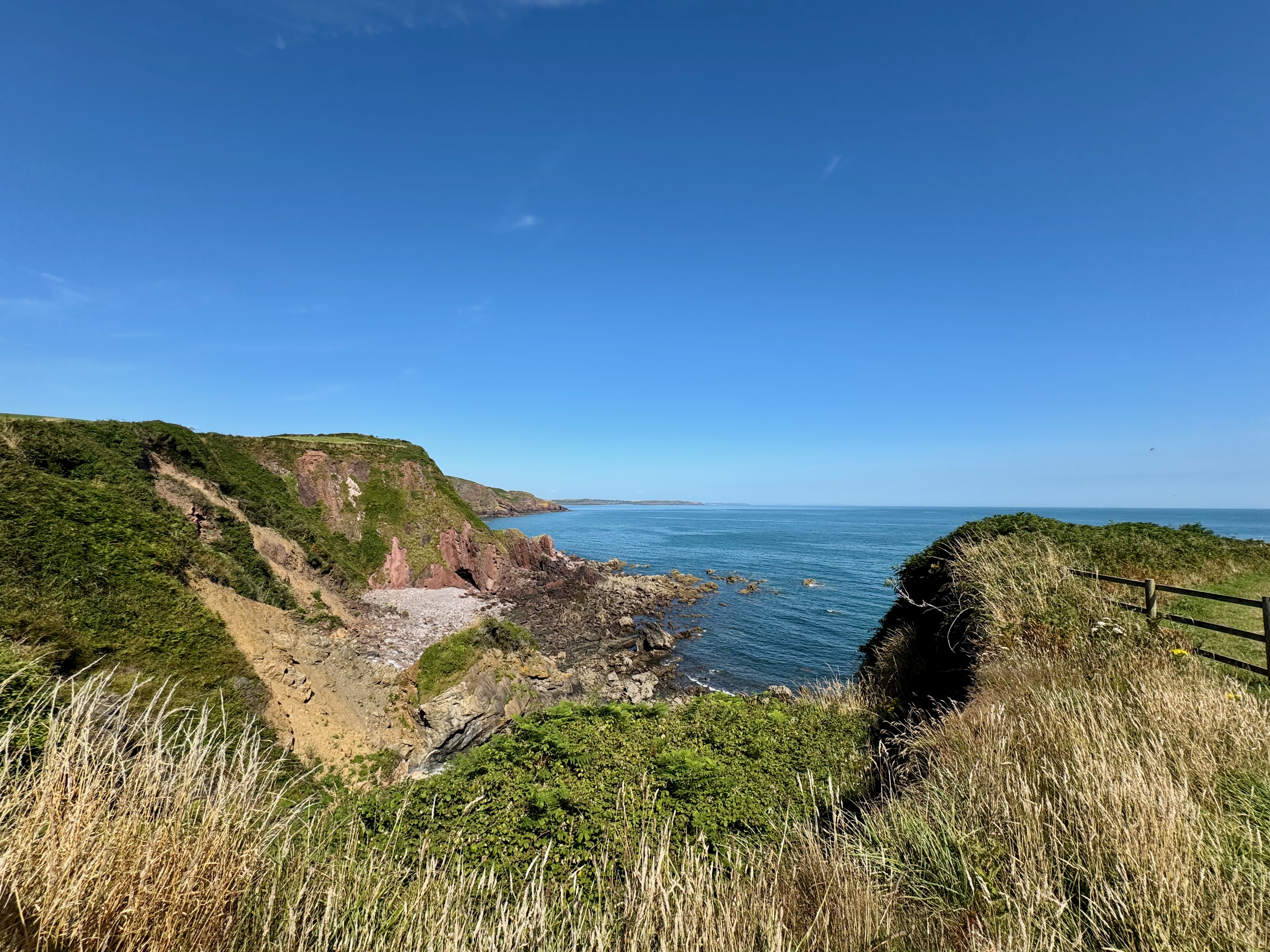 A small bay surrounded by landslips with lots of rocks all around the bay.