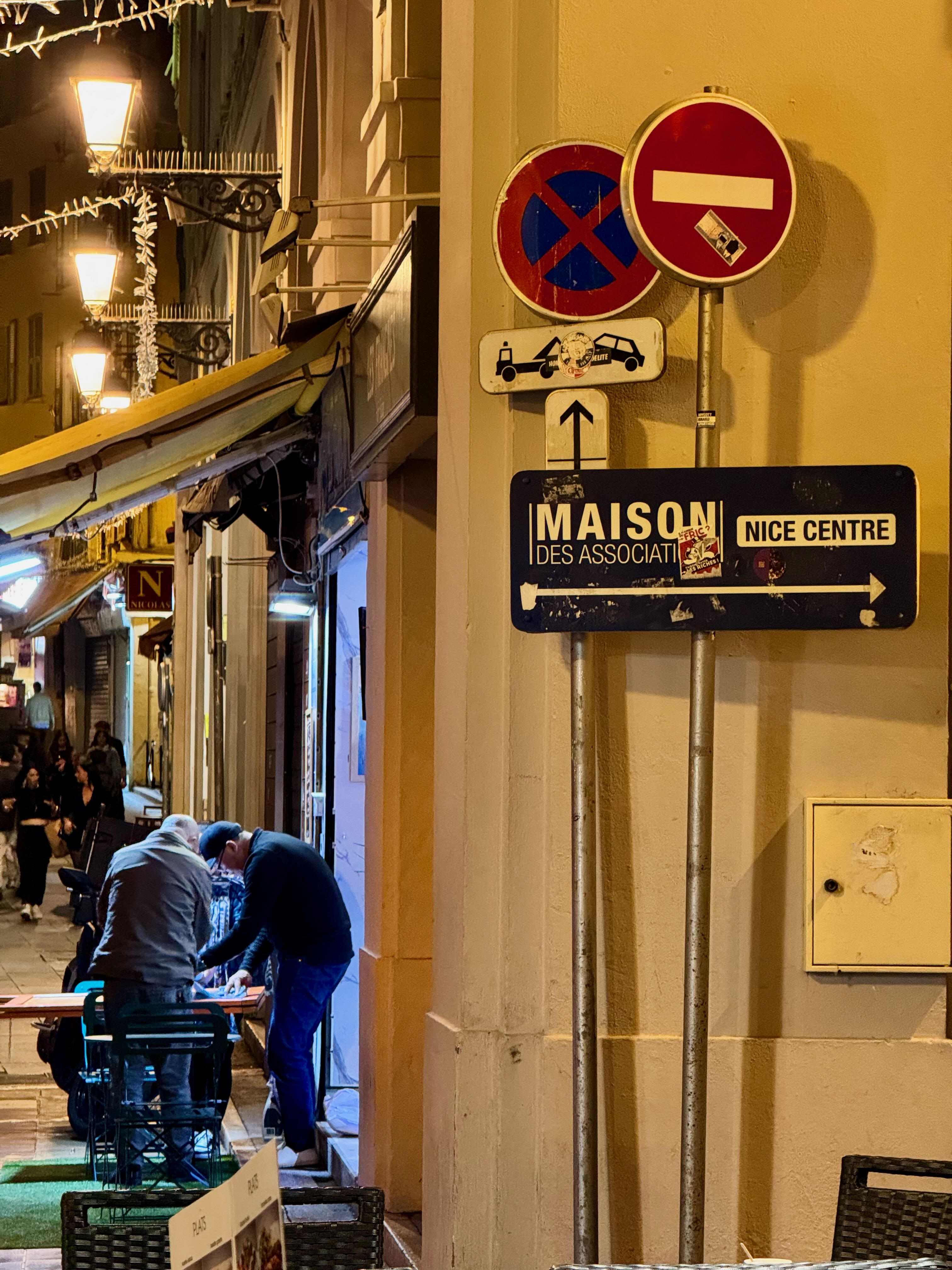 French traffic signs. people in background hunched over a table at night.