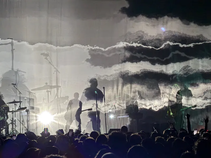 Close up of Trent silhouetted while playing guitar. 