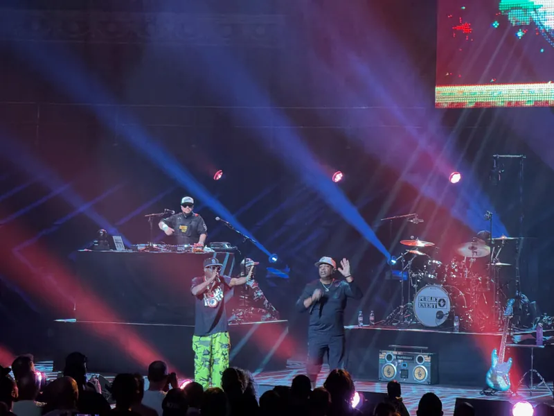 Flava Flav and Chuck D on stage with Johnny Juce in the background