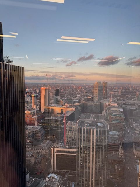 Looking over the city from the 35th floor of 22 Bishopsgate near sunset with the orange light reflecting off the buildings of east London