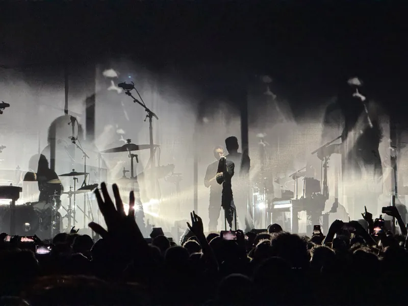 Close up of Trent silhouetted while singing into the microphone