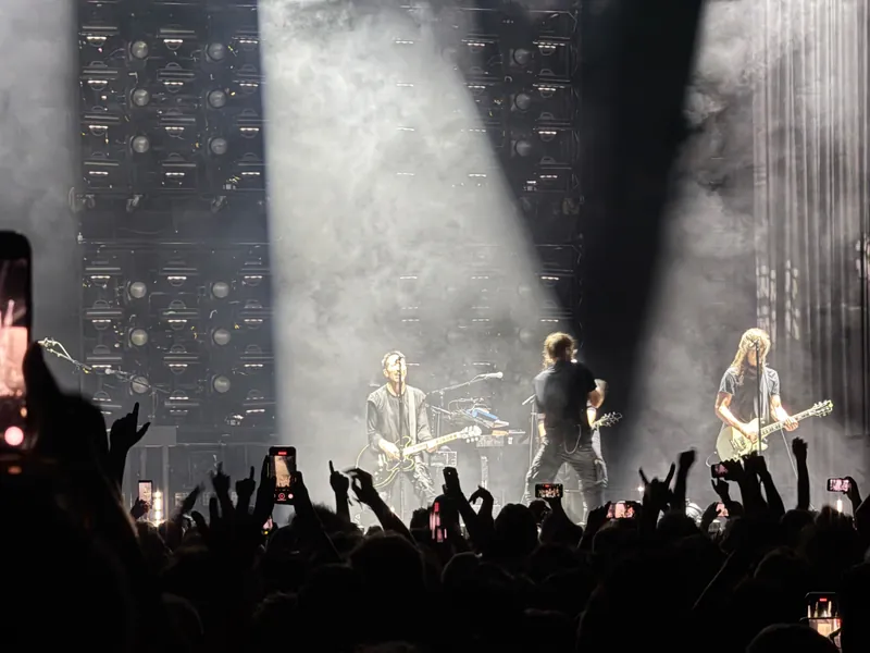 beams of white light coming down on Trent as he plays the guitar.