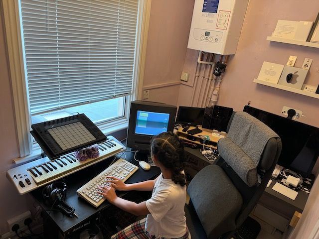 wide shot of my office with my daughter sitting at the desk typing on a Performa 5400/180