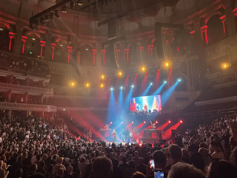 Wide shot of the hall with the stage at one end. The entire hall is lit with red and blue lights